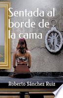 Sentada al borde de la cama